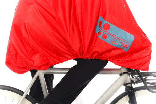 protection de cuisses contre la pluie Gros plan sur le systeme KDS® de la cape de pluie, protection intégrale FULAP rouge haute visibilité avec motifs rétroréfléchissants bleu